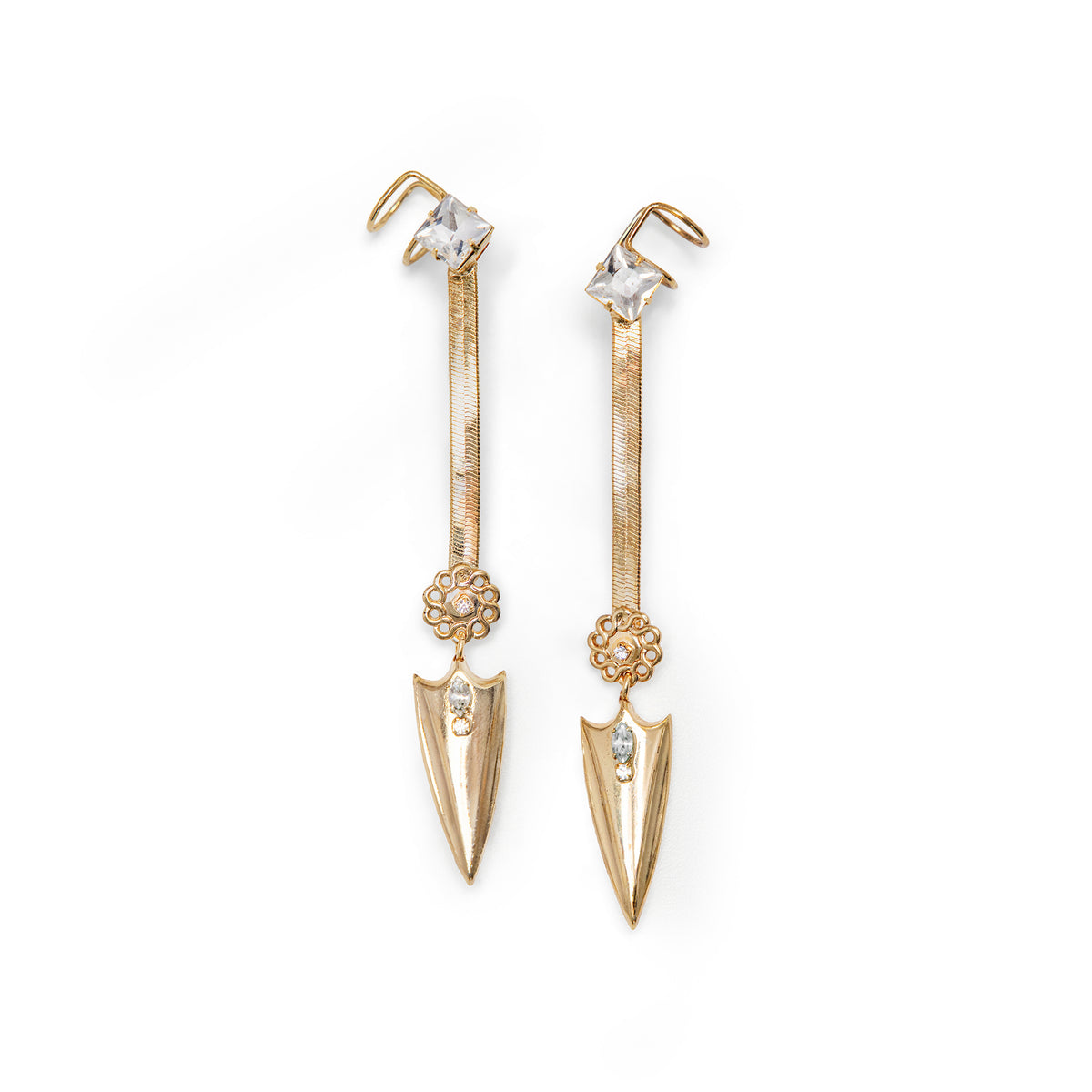 A pair of gold-toned dangle snake chain earrings with attached faux cuff and clear Swarovski crystal accents, and pointed arrowhead charm at the bottom on a white background