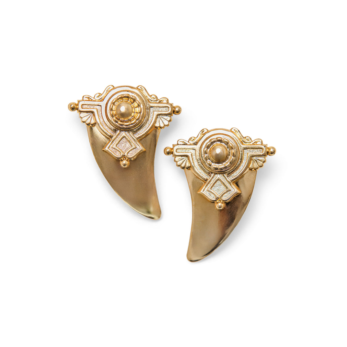 A pair of gold-toned shark tooth-shaped stud earrings with geometric detail shown on a plain white background.