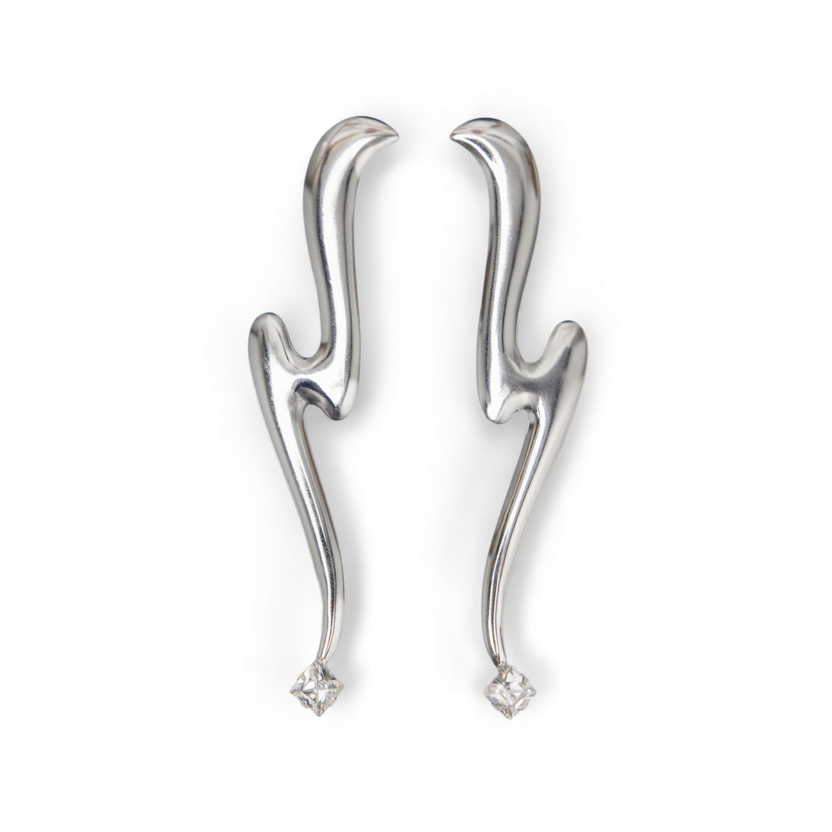 A pair of abstract, curved silver earrings with a small clear Swarovski crystal accent at the bottom, displayed on a clean white background.